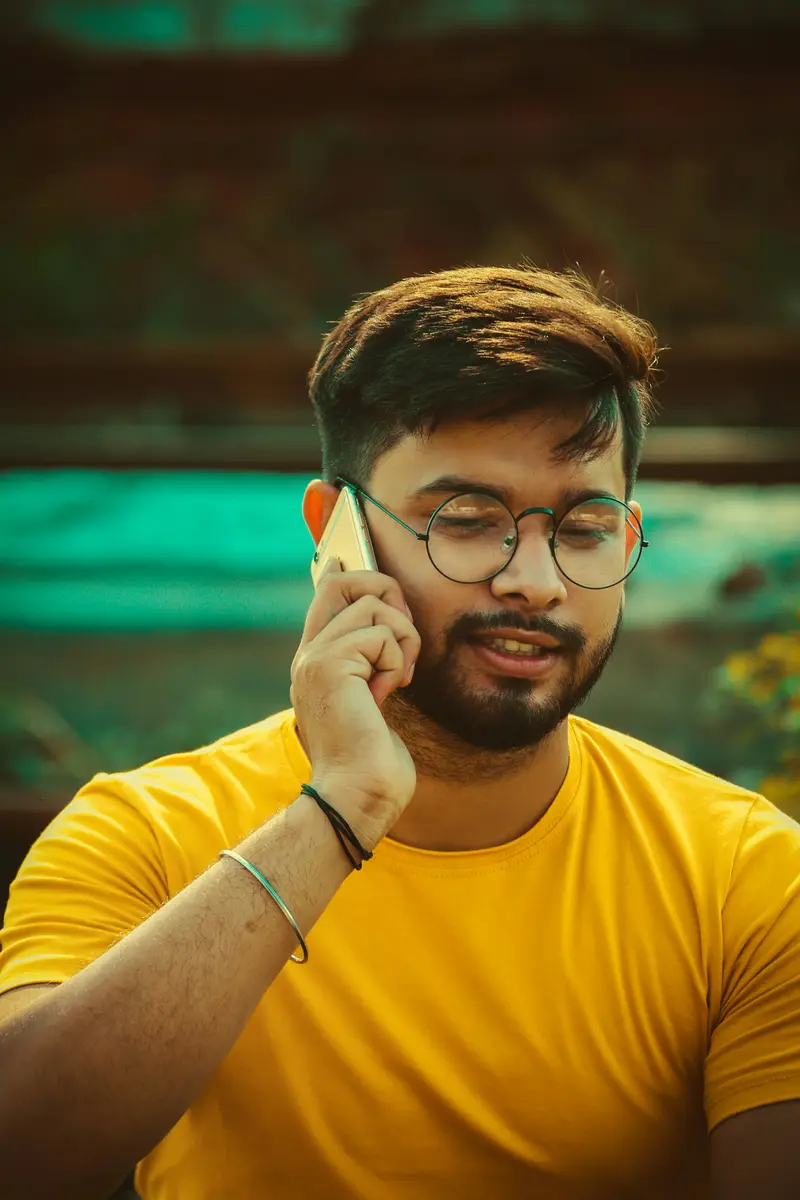 A man smiling while talking on his phone